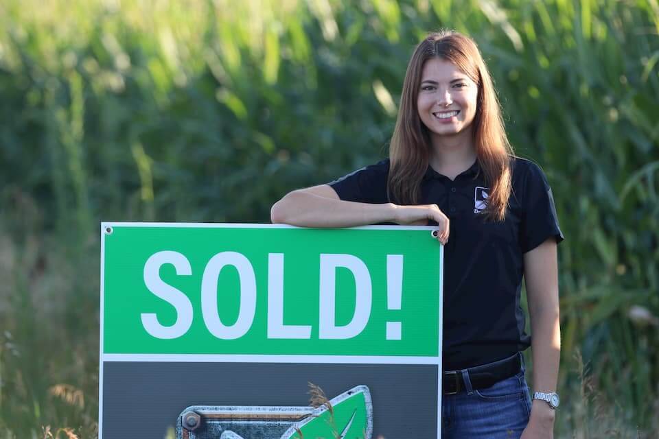 A DreamDirt representative poses with a Sold sign