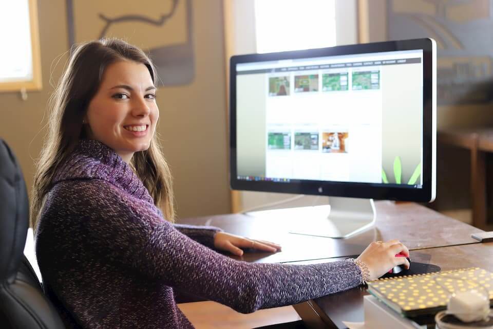 A DreamDirt representative smiles while working with an online auction.