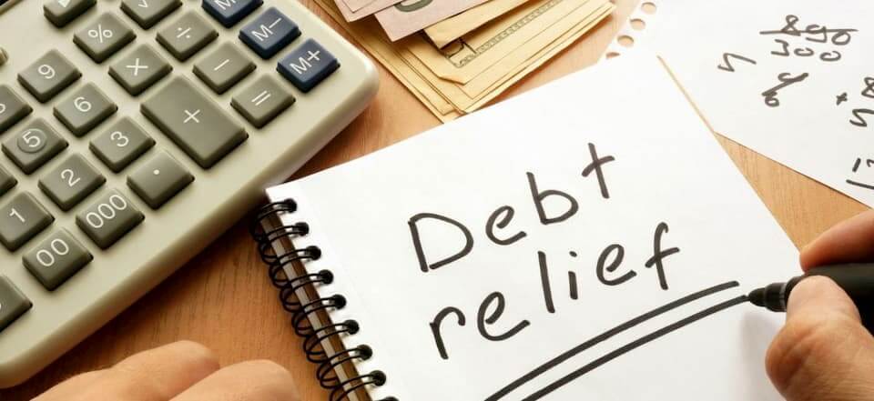 The words "Debt Relief" are written on a notepad.