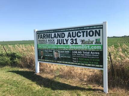 A photo of an in-person auction advertisement on the side of the road.