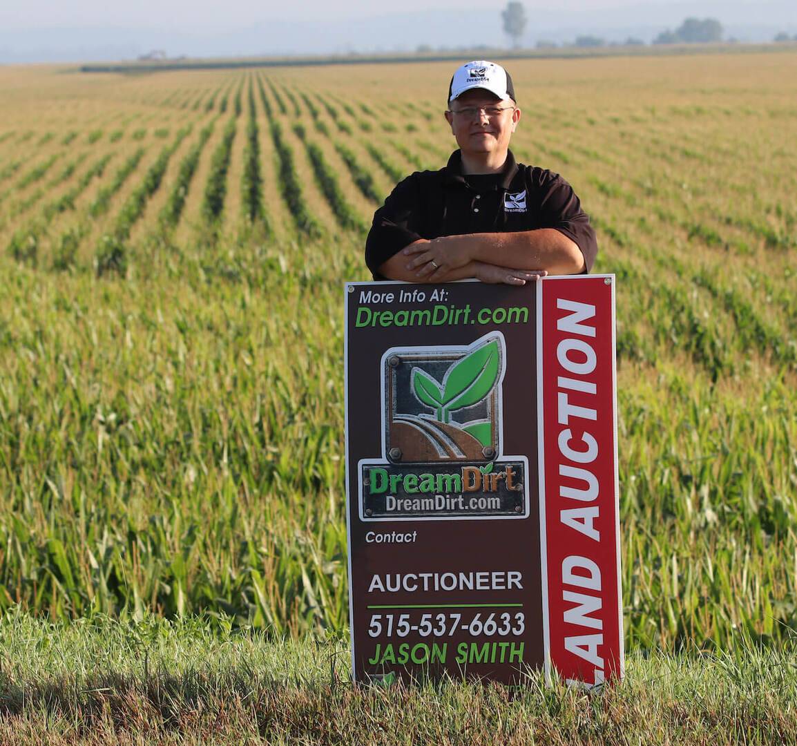 auctioneer with land for sale sign