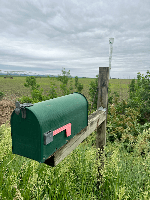 mailbox and rain gauge in iowa farm field