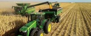 combine and tractor harvesting corn